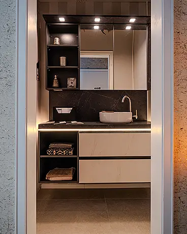 Wohnbeispiel: Kleines Badezimmer / Gästebad: Blick in ein kleines Bad mit dunkler Wand und weißem Waschbecken mit großem Spiegel. 